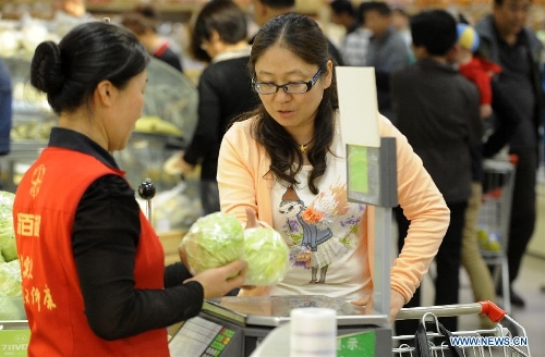 A consumer weighs vegetable at a supermarket in Yinchuan, capital of northwest China's Ningxia Hui Autonomous Region, May 8, 2013. China's consumer price index (CPI), a main gauge of inflation, grew 2.4 percent year on year in April, up from 2.1 percent in March, the National Bureau of Statistics (NBS) said Thursday. The NBS attributed the gain mainly to an unusual increase in vegetable prices during that month as low temperatures and scarce rainfalls disrupted supplies. (Xinhua/Li Ran)