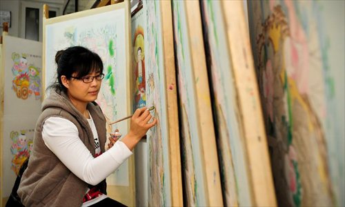 An apprentice of Huo Qingyou, a woodcut new year picture artist, adds colour to ink rubbings in Yangliuqing town, north China's Tianjin Municipality, Dec. 28, 2012. In Yangliuqing, dubbed 