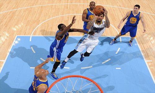 Wilson Chandler (in white) of the Denver Nuggets shoots against the Golden State Warriors on Tuesday. Photo: CFP