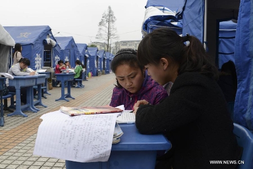 High school students study to prepare the college entrance exam this summer outside tents at a temporary settlement at the Tianquan Middle School in quake-hit Tianquan County, Ya'an City, southwest China's Sichuan Province, April 22, 2013. A 7.0-magnitude earthquake jolted Lushan County of Ya'an City in the morning on April 20. (Xinhua/Wang Jianhua)