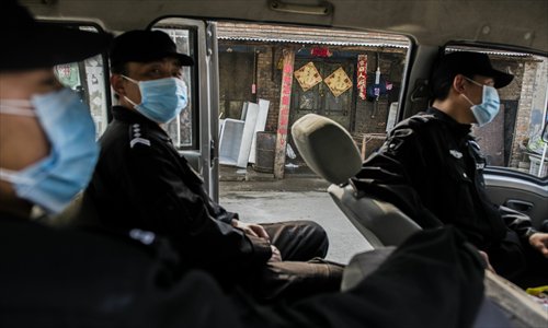 Security guards wearing masks on duty in their car on Monday, where they were preventing people approaching the home of a four-year-old H7N9 flu virus carrier surnamed Zhu in Naidong village, Chaoyang district, Beijing. Photo: Li Hao/GT