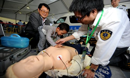 A child learns how to give first aid to a medical dummy at the Shanghai Science and Technology Festival in a park of Pudong New Area. Medical staff gave visitors lessons in emergency medical treatment, including how to bandage wounds. Photo: Yang Hui/ GT
