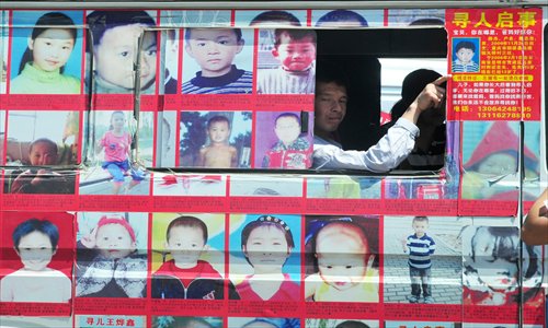 A father whose child was kidnapped looks out the window of a van covered in photos of missing children in Fuzhou, Fujian Province on Thursday. The van, financed by a charity group, has toured over 20 cities across the country. Photo: CFP
