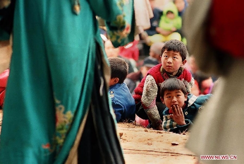 &nbsp;Children watch theatrical performance at an outdoor plaza in Weihui City, central China's Henan Province, Feb. 6, 2003. Village theatrical performances are usually given by local troupes during the Spring Festival or Chinese Lunar New Year in central China region. Chinese people who live in the central China region have formed various traditions to celebrate the Chinese Lunar New Year. (Xinhua/Wang Song)