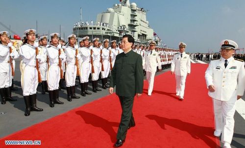 Chinese President Hu Jintao, also chairman of the Central Military Commission (CMC), inspects the guard of honor on the aircraft carrier 