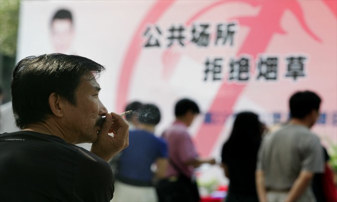 A man smokes on a square where an activity promoting non-smoking in public sites is being held in Wuhan, Hubei Province. Photo: CFP