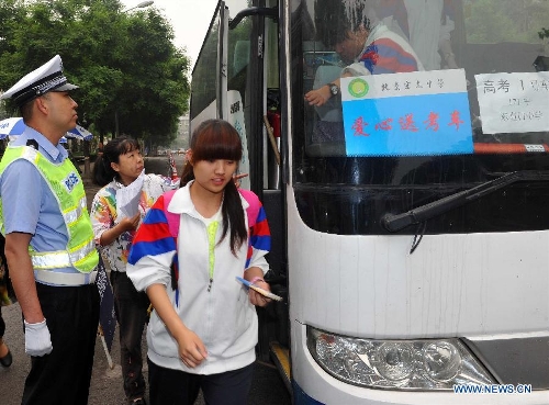 Examinees arrive to take the national college entrance exam at the Dongzhimen Middle School in Beijing, capital of China, June 7, 2013. Some 9.12 million applicants are expected to sit this year's college entrance exam on June 7 and 8. (Xinhua/Gong Lei)