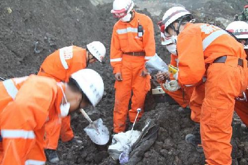 Rescuers carry out an on-site assistance after the mudslide occurred at an iron ore mine in the township of Araltobe in Xinyuan County, Northwest China's Xinjiang Uyghur Autonomous Region, July 31, 2012. The mud and debris buried 28 people, two were reported dead and 26 others missing, the local government said. Photo: Xinhua