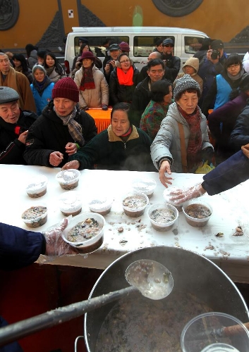   Citizens get porridge at the Yufo (Jade Buddha) Monastery in Shanghai, east China, Jan. 19, 2013, to celebrate the traditional Laba Festival. Laba literally means the eighth day of the 12th lunar month. The Laba Festival is regarded as a prelude to the Spring Festival, or Chinese Lunar New Year, the most important occasion of family reunion, which falls on Feb. 10 this year. Eating porridge is an old tradition on the Laba Festival in China. Many temples also have the tradition of offering porridge to the public to commemorate Buddha and deliver his blessings to both believers and non-believers. (Xinhua/Ren Long) 