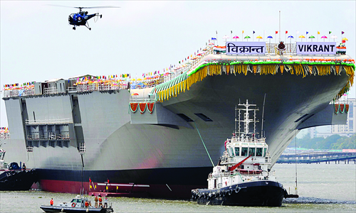 A tugboat guides the indigenously built aircraft carrier INS Vikrant as it leaves the shipyard after the launch ceremony in Kochi on Monday. Photo: AFP