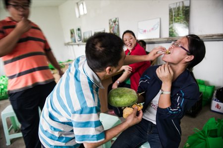 Jiao Jian, 39, a student at the center, feeds a mooncake to his teacher while others look on.  Photo: Li Hao/GT