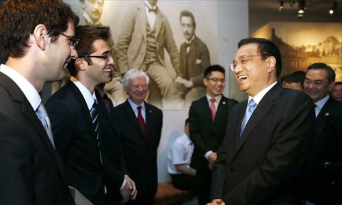 Chinese Premier Li Keqiang (R, front) talks with local residents as he visits the Einstein museum in Bern, Switzerland, May 25, 2013. Photo: Xinhua