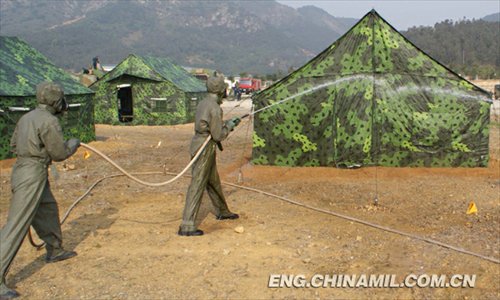 A shore-based mobile anti-ship-missile regiment under the South China Sea Fleet of the Navy of the Chinese People’s Liberation Army (PLA) organized a NBC (nuclear, biological and chemical) defense drill against actual-combat background on April 7, 2013. The picture shows the officers and men of the regiment are carrying out decontamination and detection of chemical agents in the infected “toxic” areas. (China Military Online/Sheng Yuehua, Zhao Changhong and Zheng Can)