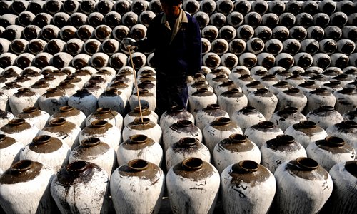 A worker checks the fermentation process of yellow rice wine in Shaoxing, East China's Zhejiang Province Tuesday. The city exported 7,396 tons of yellow rice wine worth $14.26 million in the first half of 2012, and 70 percent of the export volume went to Japan, according to the local entry-exit inspection and quarantine bureau. Photo: CFP 
