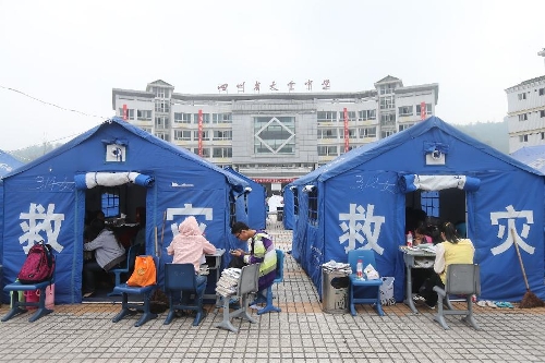 High school students study to prepare the college entrance exam this summer outside tents at a temporary settlement at the Tianquan Middle School in quake-hit Tianquan County, Ya'an City, southwest China's Sichuan Province, April 22, 2013. A 7.0-magnitude earthquake jolted Lushan County of Ya'an City in the morning on April 20. (Xinhua/Xing Guangli)