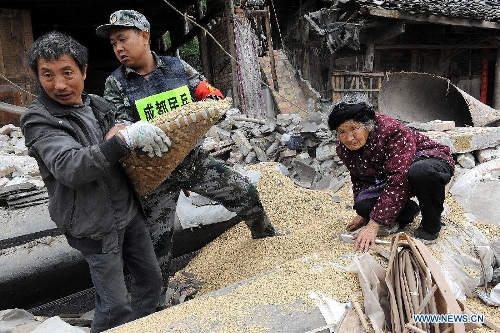 A militiaman and a villager help Zhang Zhizhen (1st R), a 83-year-old villager, transfer her grain out of the ruins of her house at the quake-hit Lushan County, southwest China's Sichuan Province, April 21, 2013. A 7.0-magnitude earthquake jolted Lushan County on April 20, leaving at least 192 people dead and 23 missing. More than 11,000 people were injured. (Xinhua/He Junchang) 