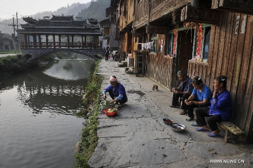 People do housework in Dimen Dong minority village in Liping County of southwest China's Guizhou Province, June 21, 2013. Dimen is a Dong minority village with about 2,500 villagers. It is protected properly and all the villagers could enjoy their peaceful and quiet rural life as they did in the past over 700 years. (Xinhua/Ou Dongqu)