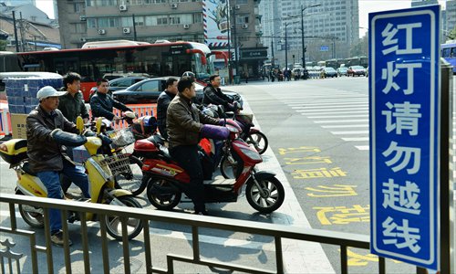 Cyclists wait for traffic lights behind the white line at the intersection of Huancheng North Road and Hushu North Road in Hangzhou, Zhejiang Province, on March 7, 2013. Photo: CFP