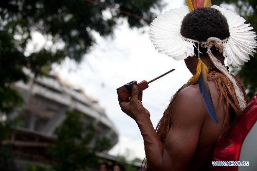 An indigenous man gazes at Maracana Stadium at the old Indian Museum in Rio de Janeiro, Brazil, Jan. 16, 2013. The government of Rio de Janeiro plans to tear down an old Indian museum beside Maracana Stadium to build parking lot and shopping center here for the upcoming Brazil 2014 FIFA World Cup. The plan met with protest from the indigenous groups. Now Indians from 17 tribes around Brazil settle down in the old building, appealing for the protection of the century-old museum, the oldest Indian museum in Latin America. They hope the government could help renovate it and make part of it a college for indigenous Indians. (Xinhua/Weng Xinyang) 