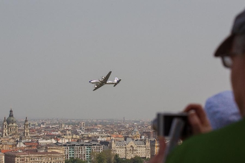 &nbsp;A tourist takes photos of an airplane flying during an air show above river Danube crossing central Budapest, Hungary, on May 1, 2013. (Xinhua/Attila Volgyi) 