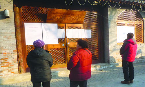 Gulou residents read the posted notice about the demolitions and renovations. 