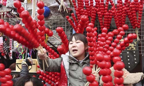 A vendor cries her sugar-coated haws at a templ fair held to celebrate Chinese Lunar New Year, or Spring Festival, in the Ditan Park, Beijing, capital of China, Feb. 10, 2013. Various activities were held all over China on Sunday to celebrate the Spring Festival, marking the start of Chinese lunar Year of the snake. The Spring Festival falls on Feb. 10 this year. Photo: Xinhua