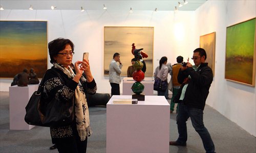 Visitors check out an exhibit at Shanghai Art Fair 2012 at the Shanghai Mart Thursday. A total of 146 galleries from 12 countries joined the exhibition, which runs until Sunday. Photo: Global Times