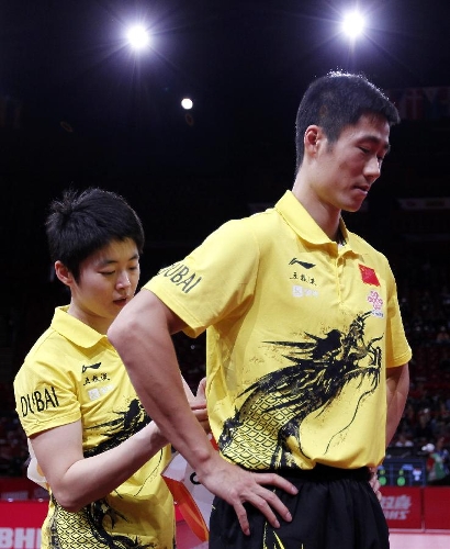 Rao Jingwen (L) of China helps her partner Wang Liqin take off his number bib after the first round of mixed doubles against Thavisack Phathaphone and Thiphakone Southammavong of Laos at Palais omnisport de Paris Bercy in Paris, France, on May 14, 2013. Wang and Rao won 4-0. (Xinhua/Wang Lili) 