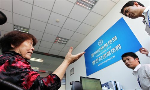 A customer asks about the lending process at the opening of the Wenzhou Private Lending Service Center in Wenzhou, East China's Zhejiang Province on April 26, 2012. Photo: CFP