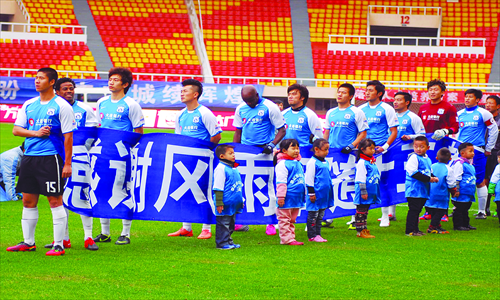 Players of Dalian Shide Football Club salute their fans at their last game on November 3 in Dalian, Liaoning Province, where the club is based. Photo: CFP
