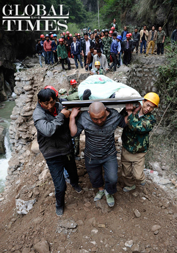 Rescuers carry an injured person from Lingguan on the way in the neighboring town of Daxi on Sunday. Photo: Li Hao/GT