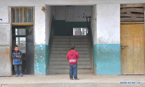 Two students stand by the scene of a stampede accident at the Qinji Elementary School in Xueji County of Xiangyang, central China's Hubei Province, Feb. 27, 2013. Four students were killed in a stampede accident here on Wednesday morning. Relevant departments of Xiangyang have rushed to the scene to carry out rescue efforts, and the injured have been sent to hospital for treatment. The cause of the accident is under investigation. Photo: Xinhua
