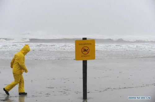 A journalist walks along the beach in Atlantic City, New Jersey, the United States, October 29, 2012. Hurricane Sandy is on Monday churning its way towards the U.S. East Coast, poised to make landfall near Atlantic City on Jersey Shore in the evening. The city itself is like a ghost town, with casinos shuttered, tourists fled and many parts of the town inundated in knee-high water. Photo: Xinhua