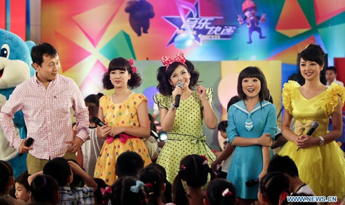 A host and hostesses from the Children's Channel of China Central Television (CCTV), attend a promoting activity of the channel in Beijing, capital of China, July 7, 2012. A series of new programs will be presented at the channel during the summer vacation. Photo: Xinhua 