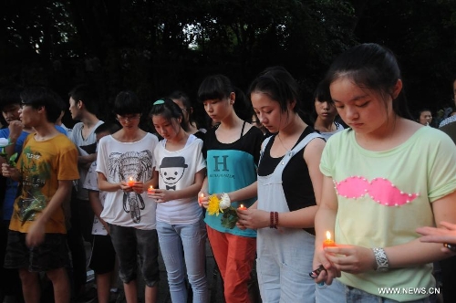 Students light candles to mourn the death of Wang Jialin and Ye Mengyuan, two young girls killed in a crash landing of an Asiana Airlines Boeing 777 at San Francisco airport, in Jiangshan City, east China's Zhejiang Province, July 8, 2013. Local residents gathered at Xujiang Park in Jiangshan to show their grief to the 17-year-old Wang and 16-year-old Ye, who were students from Jiangshan High School. (Xinhua/Huang Shuifu) 