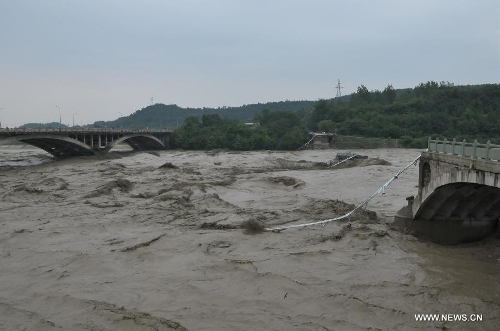  Photo taken on July 9, 2013 shows the collapsed old Qinglian Bridge (R) across the Tongkou River in Jiangyou City, southwest China's Sichuan Province. The neighboring bridge on the left is the Qinglian Bridge. An unknown number of vehicles and pedestrians fell into the river after the bridge collapsed on the morning of July 9. The water level of the river rose significantly over the past two days due to continuous rainfalls in the region. (Xinhua) 