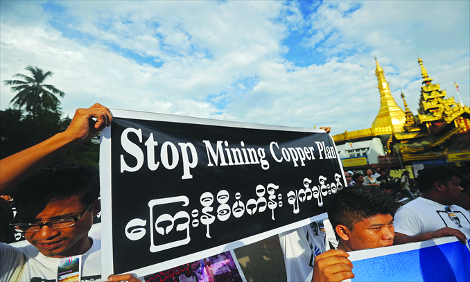 Protesters hold banners as they march against the Letpadaung copper mining plan in Yangon, Myanmar, on November 26. The project has aroused controversy for months over allegations of corruption. Photo: AFP