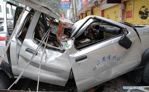 A vehicle is crushed by a fallen object in Lingguan Town of Baoxing County in Ya'an City, southwest China's Sichuan Province, April 21, 2013. A 7.0-magnitude earthquake hit Lushan County of Sichuan Province on Saturday morning, leaving 26 people dead and 2,500 others injured, including 30 in critical condition, in neighboring Baoxing County, county chief Ma Jun said. (Xinhua/Xue Yubin) 