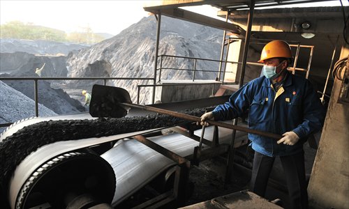 A loader shovels coal onto a conveyor belt. Photo: CFP