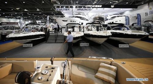 A working staff passes by boats on display at the 58th London Boat Show, held at the ExCeL Exhibition and Convention Centre in London, Jan. 14, 2013. The 58th London Boat Show showcases, demonstrates and sells maritime equipments including luxury yachts, dinghies, boating equipment and clothing with interactive sections and features attractions devoted to boating until Jan. 20, 2013. (Xinhua/Wang Lili) 
