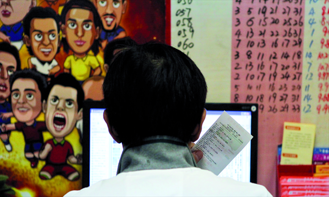 A man is lost in thought in front of a computer at a lottery sales point on June 17 in Jing'an district, Shanghai. Photo: CFP