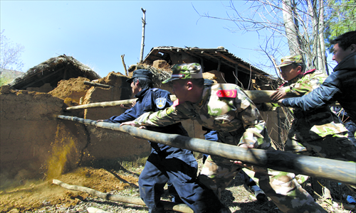Rescuers help local villagers in Qiaojia, Yunnan Province to dismantle damaged walls after an earthquake on Tuesday to avoid future risk. Photo: CFP