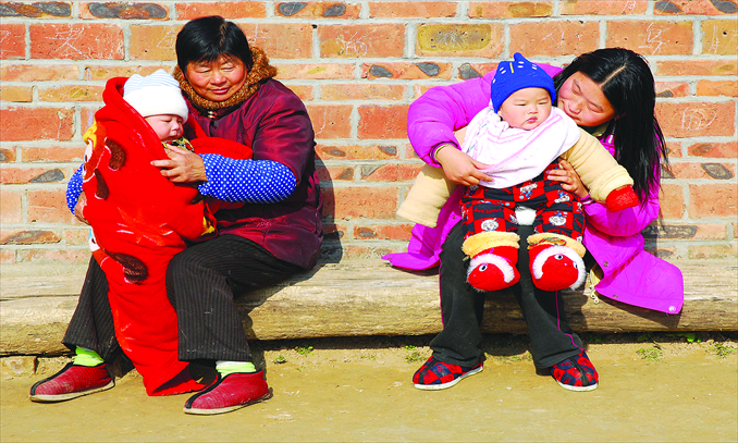 Rural women warm themselves and their kids in the sun in Huai'an, East China's Jiangsu Province. Photo: CFP