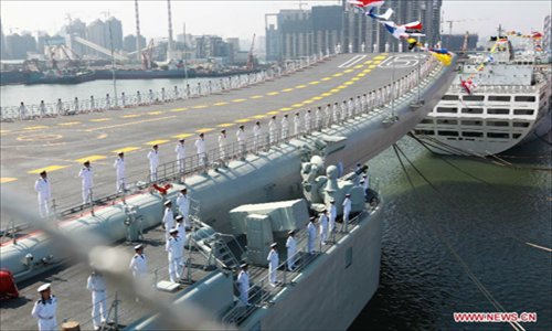 Military officers stand onboard China's aircraft carrier 