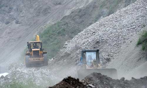 Bulldozers try to clear a road in Luozehe Town, Yiliang County, southwest China's Yunnan Province, Sept. 7, 2012. Sixty-four people have been confirmed dead and 715 others were injured after multiple earthquakes struck a mountainous region in southwest China's Yunnan Province on Friday, the province's civil affairs department said.