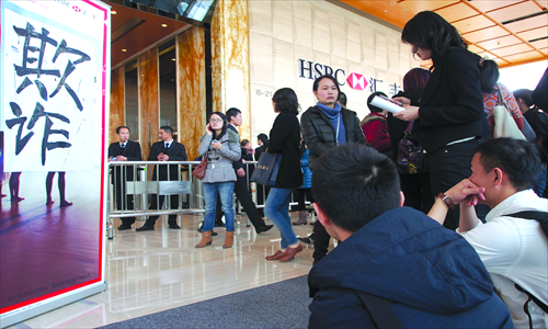 Some HSBC Life China workers protest in the lobby of the HSBC Tower in Shanghai Thursday. The Chinese characters in the picture read