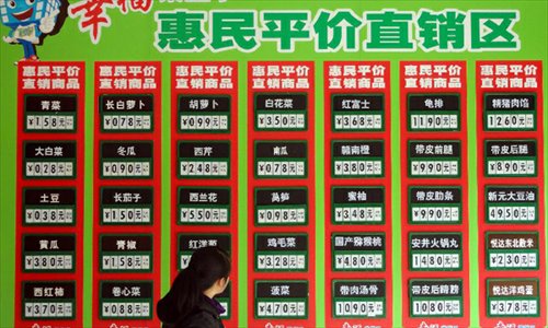 A consumer looks at sales information at a supermarket in Suzhou, east China's Jiangsu Province, December 9, 2012. China's consumer price index (CPI), a main gauge of inflation, grew 2 percent year on year in November, the National Bureau of Statistics announced Sunday. The inflation rate increased from a 33-month low of 1.7 percent in October as food prices increased. Photo: Xinhua