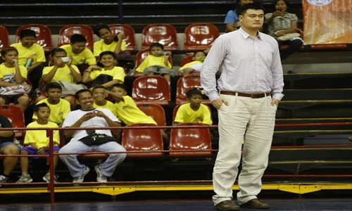 Filipino fans look on as former Chinese NBA basketball player Yao Ming (front) watches a practice session of the Shanghai Sharks basketball team at the Philippine Sports Commssion in Manila on Sunday. The Shanghai Sharks, which is owned by Yao Ming, is scheduled to play exhibition games against Filipino basketball teams in Manila on Monday and Tuesday. Photo: CFP