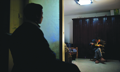 Xiao rests while his father eats noodles at a rented house near the school.Photos: Gu Pengbo