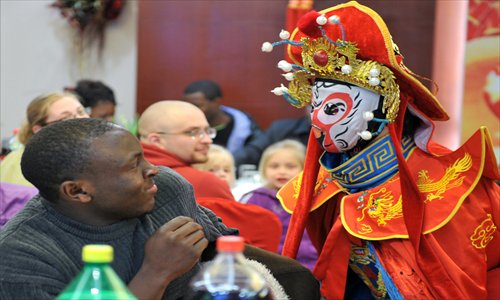 A foreign student at Nanjing Agricultural University watches a traditional face-changing performance at his school on Monday. The university arranged for some 50 foreign students from over 20 countries and a group of Chinese students to celebrate the coming Spring Festival together. Activities included making dumplings, celebrating with poetry and enjoying traditional Chinese shows. Photo: CFP